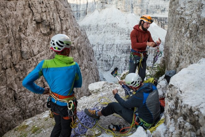 tre scalatori, di cui uno con protesi ad una gamba, sulla cima di una montagna, circondati dalle dolomiti